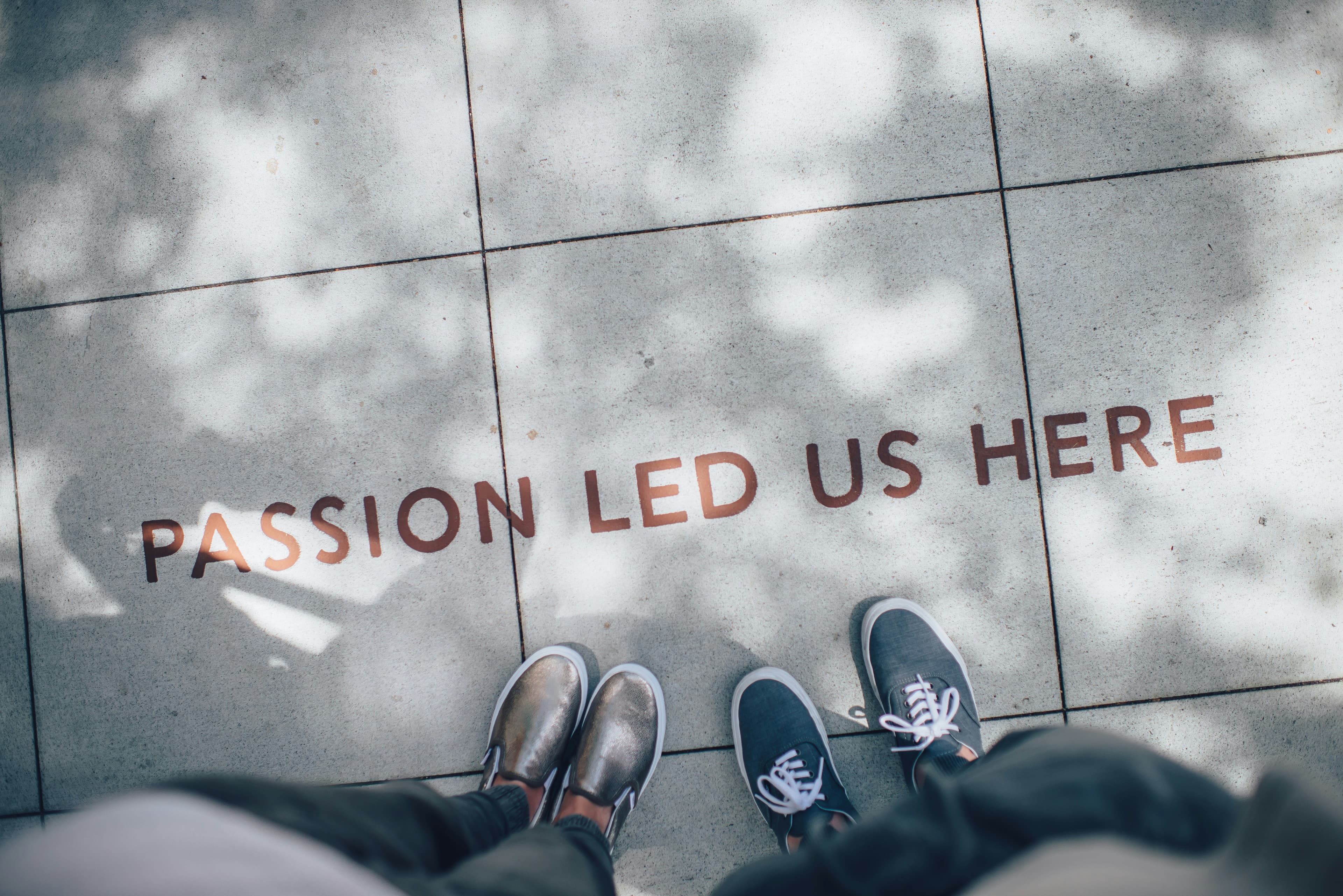 Looking down at floor with two pairs of shoes and text saying 'passion led us here'